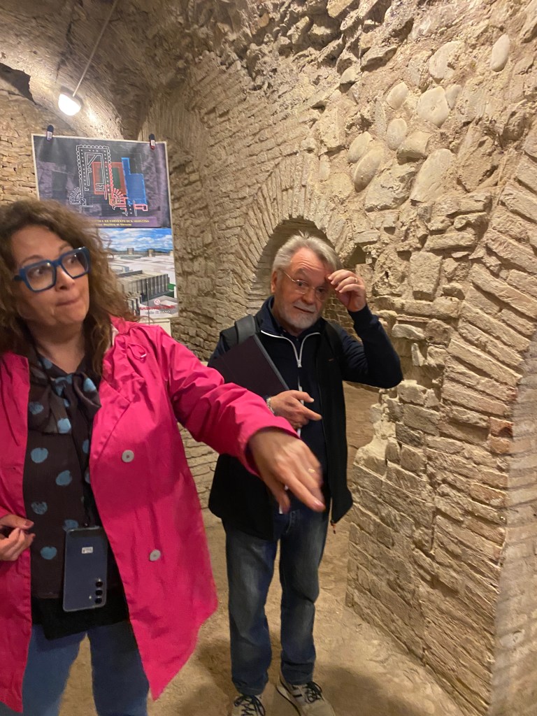 Piergiorgio Budacci, right, leads a tour group through underground Roman ruins in Fano, accompanied by an English-speaking interpreter.