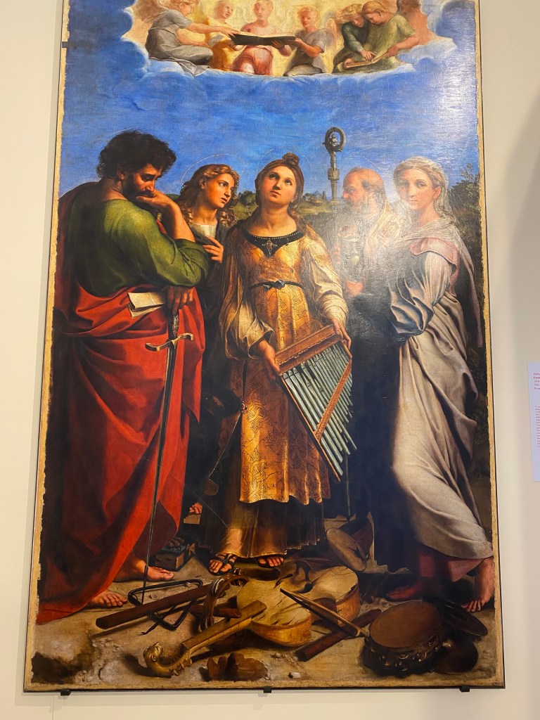 Raphael's St. Cecilia, patroness of music, letting earthly instruments fall as she ecstatically experiences the heavenly choir above her. St. Paul, left, and others don't seem to hear what she hears.